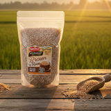 Package of brown rice with a label on a wooden surface in front of a sunset over a field.