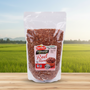 Packaged red rice with a visible brand label on a wooden surface and green field background